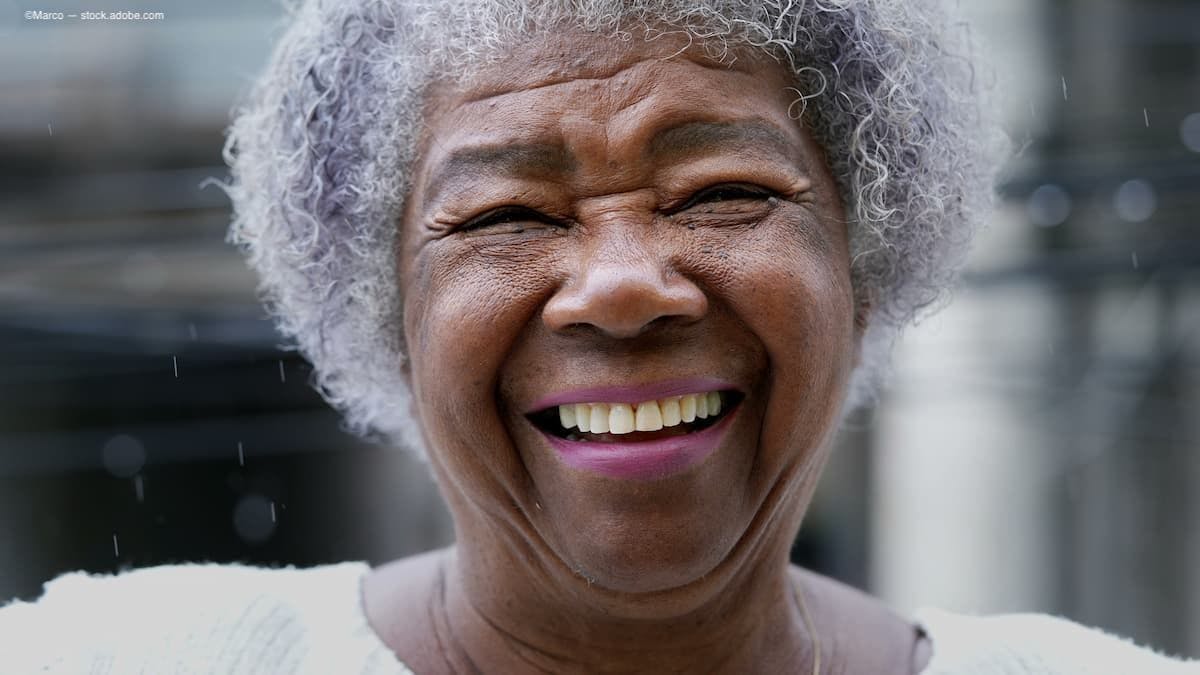 A joyful older black woman smiling into the camera (Image Credit: AdobeStock/Marco)