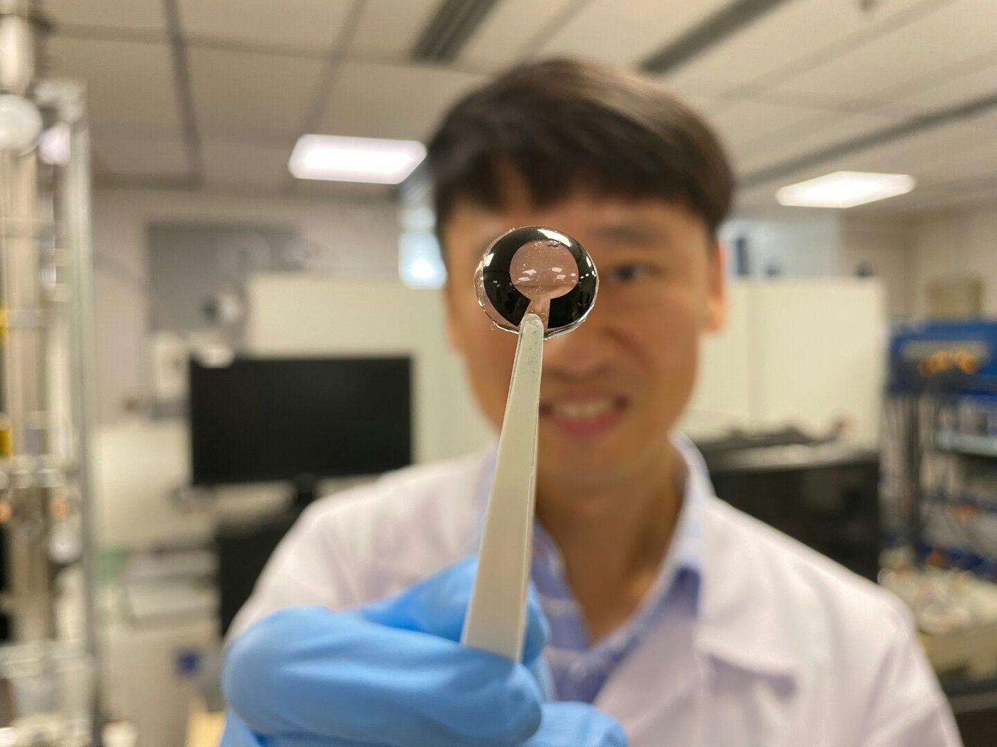 A Lee Seok Woo, PhD,an associate professor at Nanyang Technology University’s School of Electrical and Electronic Engineering, holds up the flexible battery that is as thin as a human cornea. (Image credit: NYU Singapore)